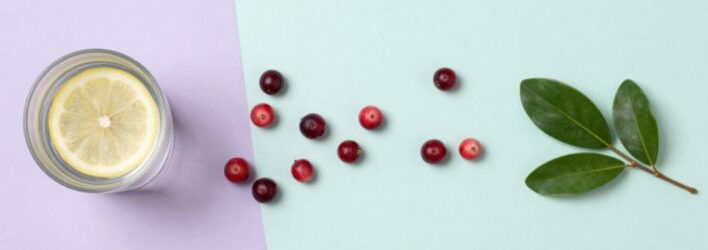 Acqua, mirtilli rossi e foglie verdi, immagine dedicata alla prevenzione della cistite dopo i rapporti e al benessere intimo femminile.
